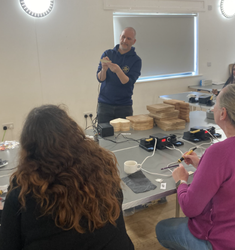 Craig from side burner demonstrating pyrography skills at the rings community hub ingleby barwick 